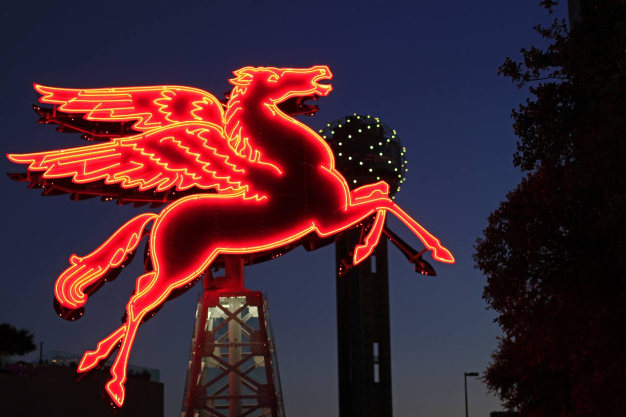 A close-up of the complete red neon Pegasus glowing in Dallas at night